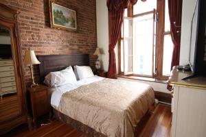 a bedroom with a bed and a brick wall at B&B de la Fontaine in Quebec City