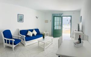 uma sala de estar com um sofá azul e cadeiras em -MONTORIAN Apartments -LANZAROTE em Tías