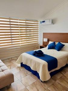 a bedroom with a large bed with blue pillows at Casa 5 habitaciones bonitas y elegante in Puerto Baquerizo Moreno