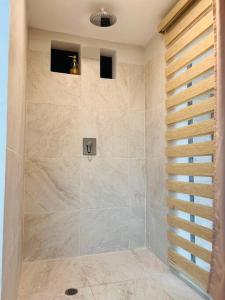 La salle de bains est pourvue d'une douche avec une porte en verre. dans l'établissement Casa 5 habitaciones bonitas y elegante, à Puerto Baquerizo Moreno