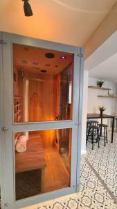 a glass door in a room with a dining room at Cabin of Light - Hot Tub, Sauna, Massage Chair, BBQ, Games, Beach in Monkwearmouth