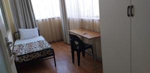 a small room with a desk and a chair next to a window at 4-Bedroom Apartment in Pretoria