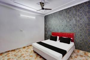 una camera con letto con testiera rossa di OYO Hotel Bliss a Nuova Delhi