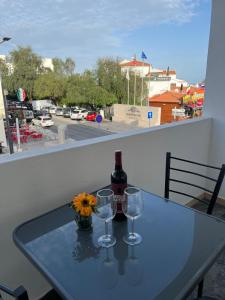 a table with a bottle of wine and two glasses at Apartamento Sunny in Albufeira