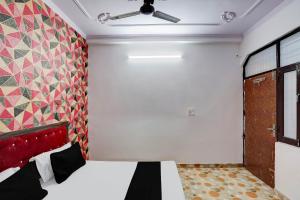 una camera con letto e parete colorata di OYO Hotel Bliss a Nuova Delhi