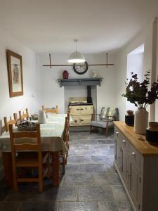 a kitchen and dining room with a table and chairs at The Farmhouse in Swansea