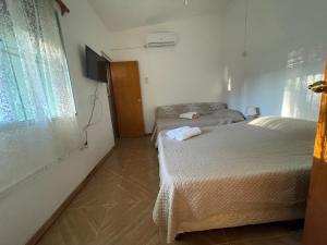 um quarto com duas camas e uma televisão em Cómodo apartamento en Minas, con amplio fondo y entrada para vehículo em Minas
