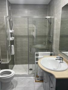 een badkamer met een douche, een toilet en een wastafel bij Apartamento Sunny in Albufeira
