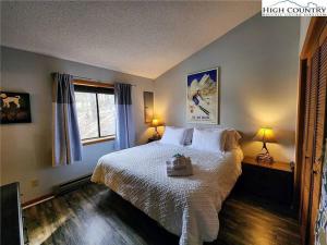 a bedroom with a bed and two lamps and a window at Cozy Cabin Walkable to Beech Mt Resort in Beech Mountain