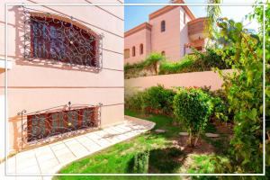 een gebouw met een poort en een binnenplaats met een boom bij RIAD TARGA - Marrakech in Marrakesh