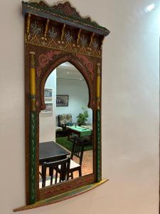 Tranquil Oasis in Chefchaouen في شفشاون: مرآة على جدار مع طاولة في الغرفة