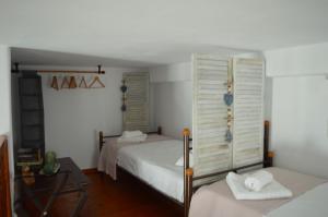 sypialnia z 2 łóżkami i oknem w obiekcie CHORA HOUSE KYTHNOS w mieście Kitnos