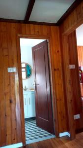 una puerta abierta en una habitación con paredes de madera en La cabaña, en Cedeira