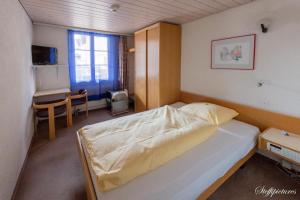 een slaapkamer met een bed en een bureau. bij Hotel Krone Uetendorf in Uetendorf