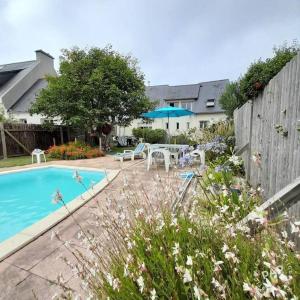 a backyard with a pool and a table and chairs at Gites des menhirs in Camaret-sur-Mer