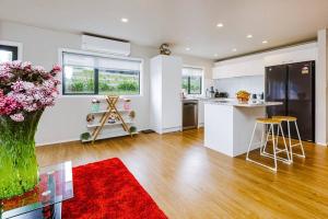 a kitchen with a vase of flowers on a table at Tranquil Countryside Retreat with Modern Amenities in Pokeno