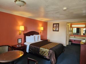 a hotel room with a bed and a table at Americas Best Value Inn-Mojave in Mojave