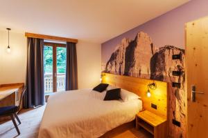 a bedroom with a bed with a rock wall at Rifugio La Montanara in Molveno
