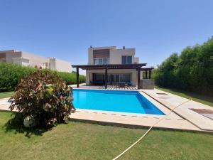 a house with a swimming pool in the yard at Hacienda bay villa in Sīdī ‘Abd ar Raḩmān