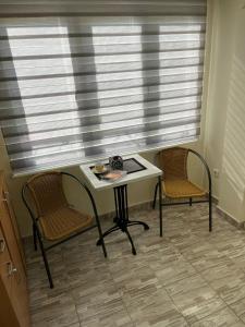 a table and two chairs in a room with a window at Vikendica Lazic in Ljubovija