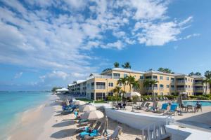 a resort on the beach with chairs and umbrellas at Regal Beach Club #533 in George Town