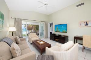 a living room with a couch and a tv at Regal Beach Club #533 in George Town