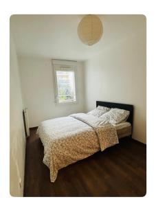 Schlafzimmer mit einem Bett und einem Fenster in der Unterkunft Chambre spacieuse et lumineuse in Nanterre