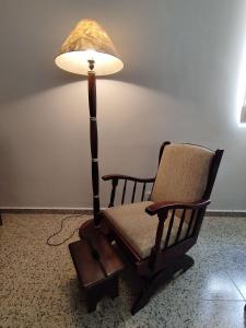 lampa siedząca obok fotela bujanego z cieniem lampy w obiekcie Centro de São Lourenço: Conforto e Praticidade w mieście São Lourenço