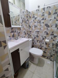 W łazience znajduje się toaleta, umywalka i lustro. w obiekcie Centro de São Lourenço: Conforto e Praticidade w mieście São Lourenço