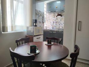 a kitchen with a wooden table with chairs and a microwave at Downtown São Lourenço: Comfort and Convenience in São Lourenço