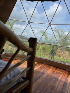 a room with a view of a large window at Refugio del Bosque CABAÑAS Y GLAMPING in Guácimo