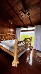ein großes Bett in einem Zimmer mit Holzdecke in der Unterkunft Refugio del Bosque CABAÑAS Y GLAMPING in Guácimo
