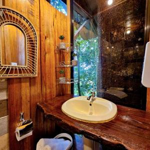 ein Bad mit einem Waschbecken und einem Spiegel in der Unterkunft Refugio del Bosque CABAÑAS Y GLAMPING in Guácimo