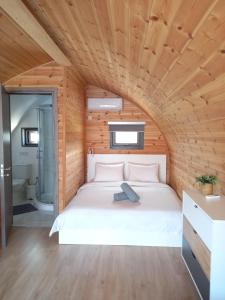 a bed in a room with a wooden ceiling at Glamping Pod in Prodhromi