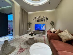 a living room with a couch and a tv at شقة غرفة وصالة وجلسة خارجية بالعارض ٨ in Riyadh