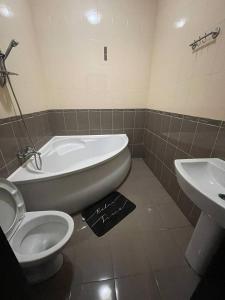 uma casa de banho com uma banheira, um WC e um lavatório. em Отель Ренессанс em Dnipro