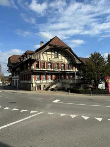 um edifício antigo ao lado de uma rua em Hotel Krone Uetendorf em Uetendorf