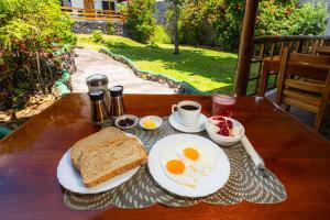 un desayuno con huevos y tostadas en una mesa de madera en La Peregrina Galapagos B&B, en Puerto Ayora