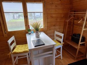 a dining room with a white table and chairs at Glückseligkeit am Waldesrand 