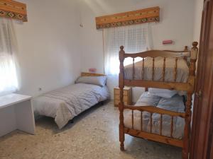 1 dormitorio con 1 litera y 1 cama individual en Casa en el campo cerca de sevilla, en La Rinconada