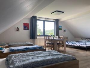 1 Schlafzimmer mit 2 Betten, einem Tisch und einem Fenster in der Unterkunft Apartmány Větrná 29 in Malšín