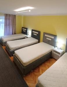 um quarto com quatro camas num quarto em Ferhadija Apartment em Sarajevo
