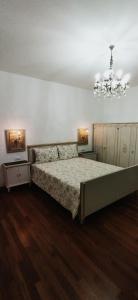 a bedroom with a bed and a chandelier at Villa Mazzini in Molinella