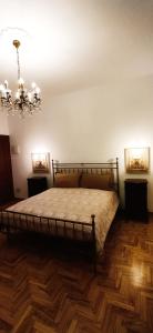 een slaapkamer met een bed en een kroonluchter bij Villa Mazzini in Molinella