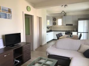 a living room with a couch and a kitchen at Apartman Relax Eco in Zaboric