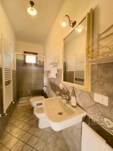 een badkamer met een wastafel, een toilet en een spiegel bij Azienda Agricola I Colli di Marliano in Lastra a Signa