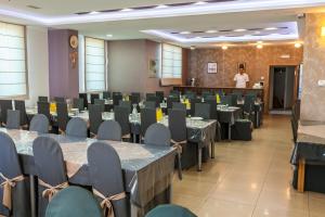 a conference room with tables and chairs and a man in a podium at Hotel Ivanković in Međugorje