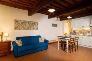 - un salon avec un canapé bleu et une table dans l'établissement Azienda Agricola I Colli di Marliano, à Lastra a Signa