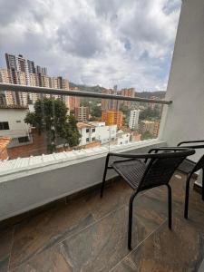 uma varanda com 2 cadeiras e vista para a cidade em Apartamento en la mejor zona de sabaneta em Sabaneta