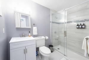 a white bathroom with a toilet and a shower at Convenient Braintree Home - 3 Bedroom Sleeps 8 in Braintree +19 photos